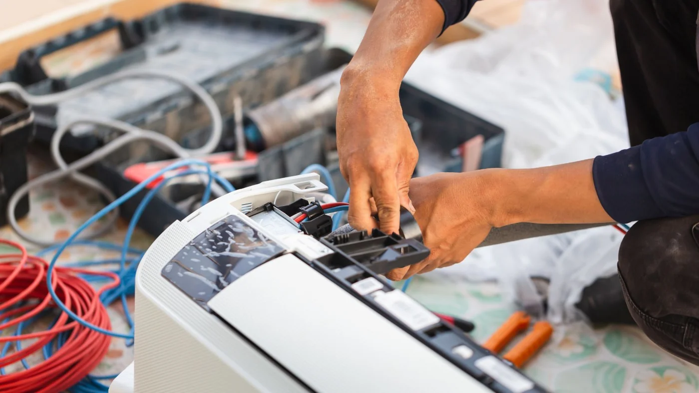 Close-up of hands testing an open air-conditioning system with service tools