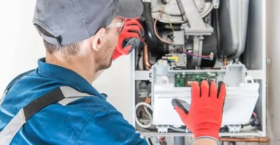 Technician inspecting the controls inside a heating system